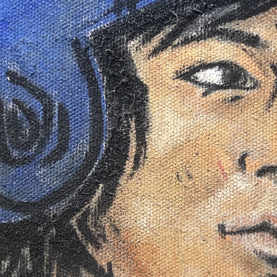 Macro detail of a painted face and batting helmet, canvas weave showing through